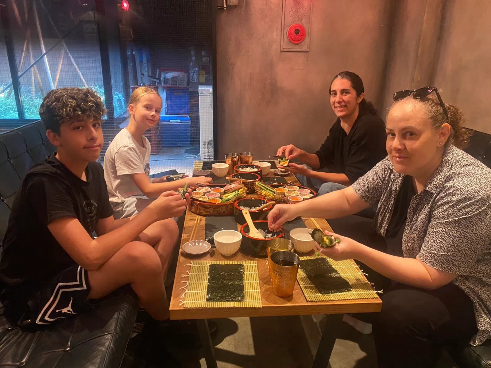 Guests making sushi together around a table at the experience